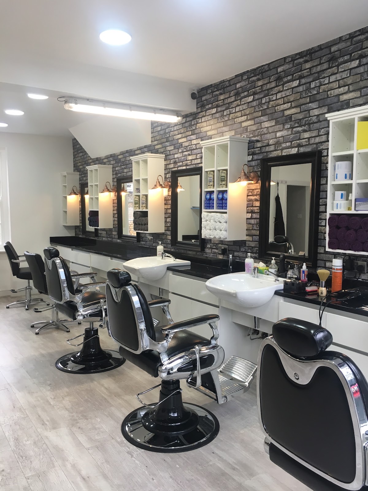 The full row of barber chairs, mirrors and basins along the wall of the shop
