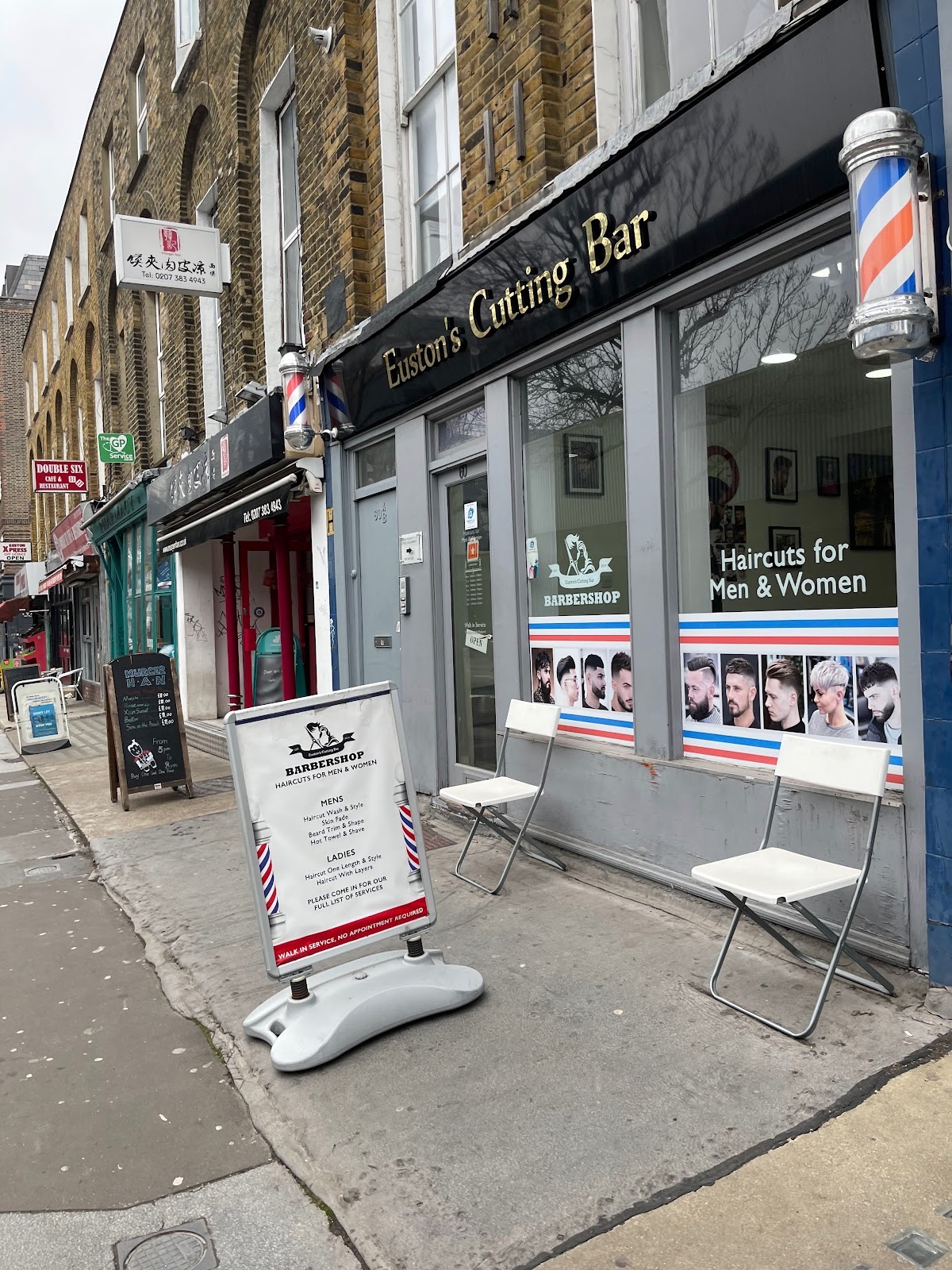 The shopfront on Eversholt Street, with barber pole and window graphics